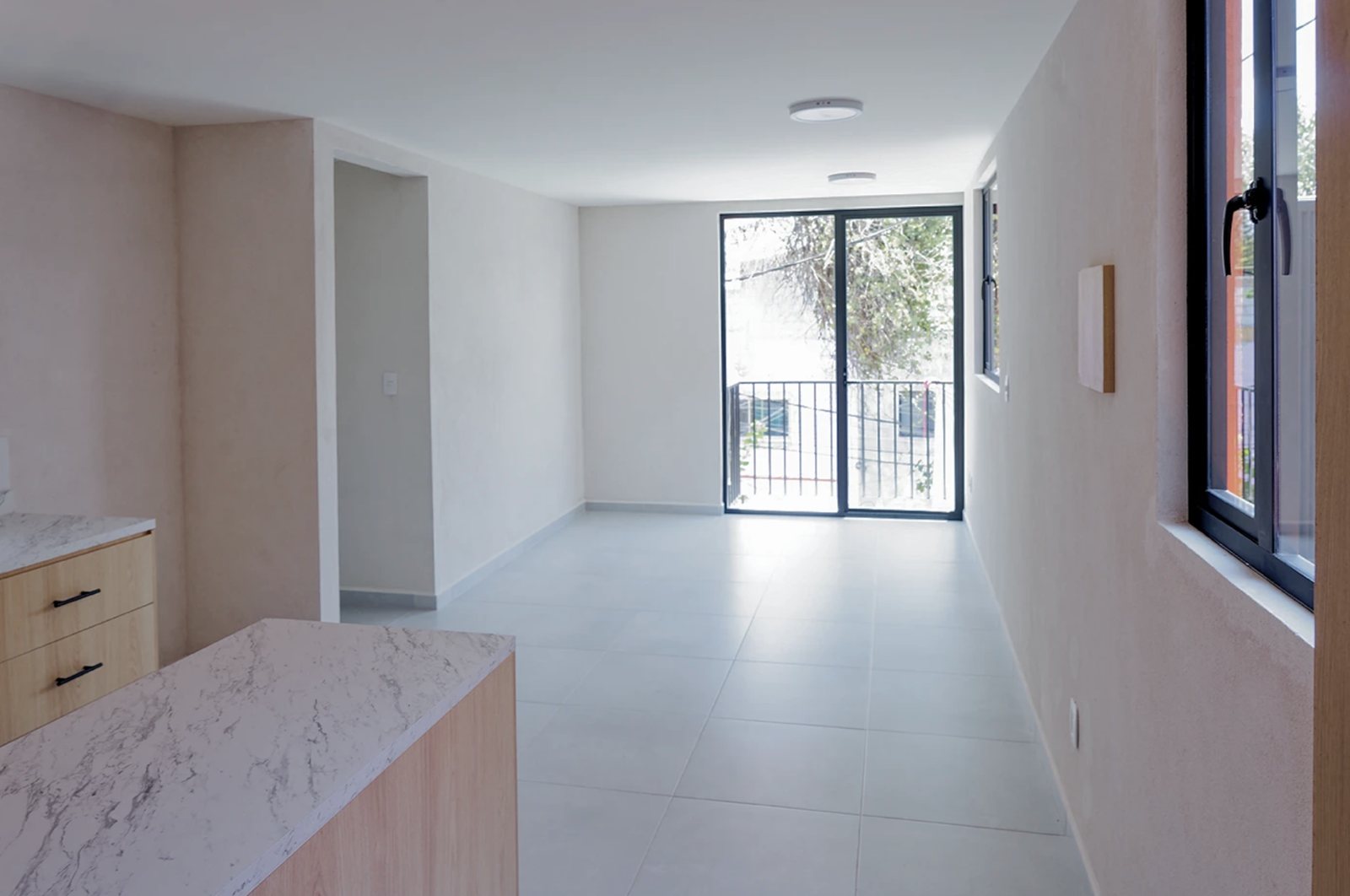 Sala con balcón de un departamento en Edificio Amelia, CDMX